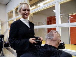 Studente tijdens de les baard trimmen