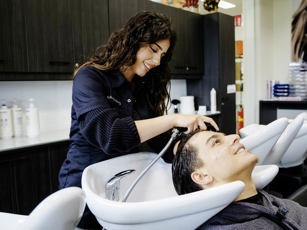 Studente haarstylist aan het oefenen met haren wassen