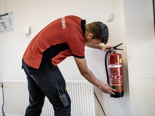 Student beveiliging checkt de brandblusser