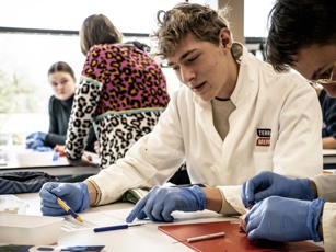Vavo student leest opdracht in de klas