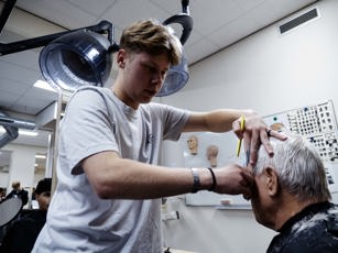 Barbier student aan het knippen tijdens de les