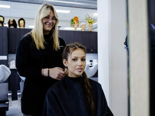Studente haarstylist en klant tijdens de les