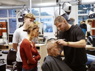 Docent barbier geeft instructies tijdens de les