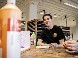 Onderwijsassistent student met verfflessen
